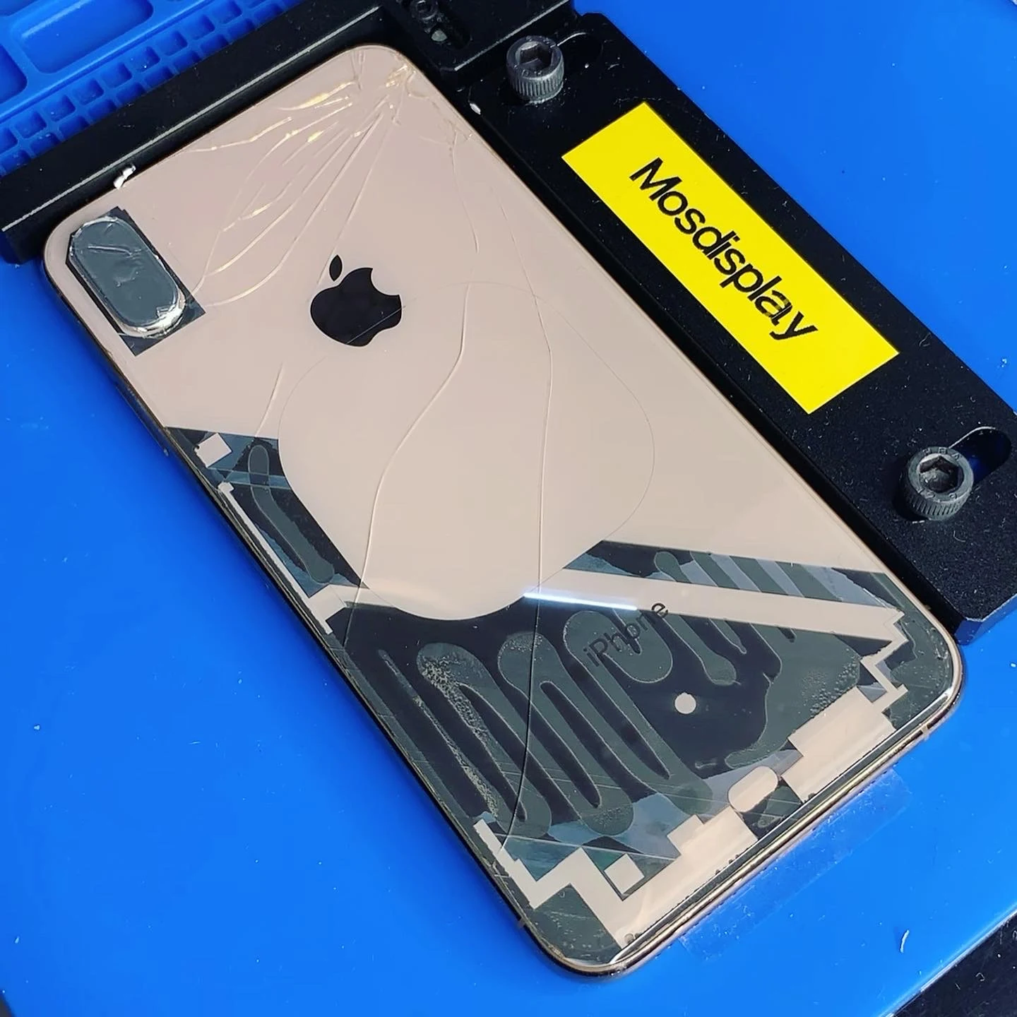 Частично снятое светлое заднее стекло iPhone в держателе