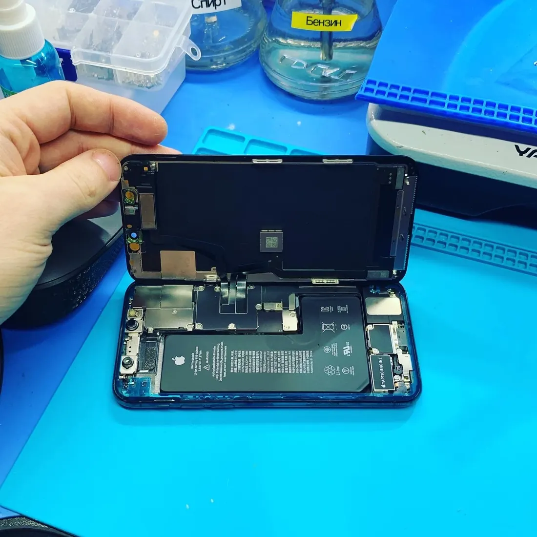 Вскрытый iPhone на столе мастера: по периметру корпуса — влагозащитный контур