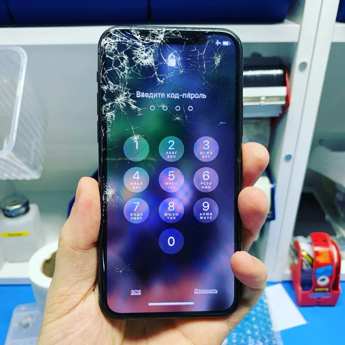 iPhone с разбитым стеклом: трещины по верхней части, изображение под ними целое